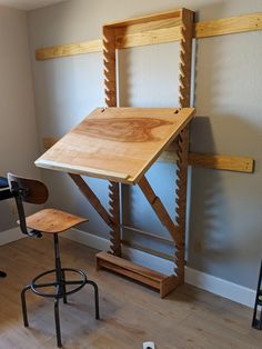 a wooden table sitting on top of a hard wood floor next to two stools