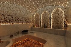 a bath room with three sinks and lights on the ceiling