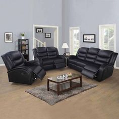 a living room filled with black furniture and a coffee table on top of a hard wood floor