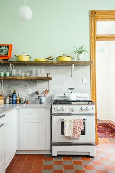 an instagram photo of a kitchen with white appliances and pink floor tiles on the walls