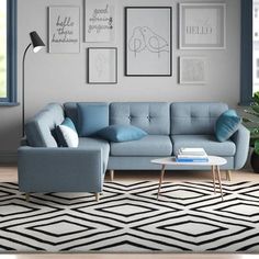 a living room with blue couches and pictures on the wall above it's coffee table