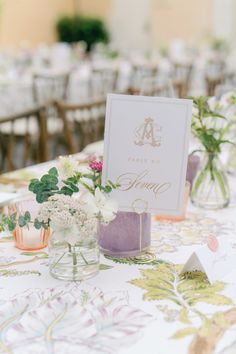 the table is set up with vases and cards for guests to write their names