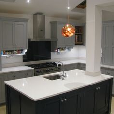 a kitchen with gray cabinets and white counter tops