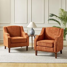 two orange chairs sitting next to each other on top of a white carpeted floor