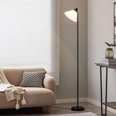 a living room scene with focus on the floor lamp and sofa in the foreground