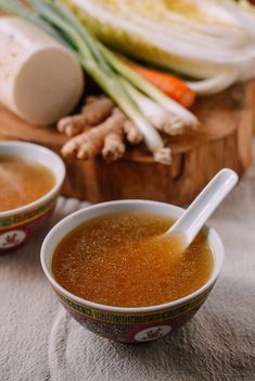 two bowls filled with soup sitting on top of a table next to sliced onions and carrots