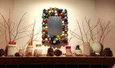 a mantel topped with lots of different types of christmas decorations and pineconis