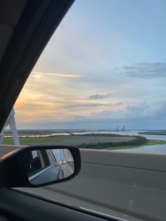 the view from inside a car looking out at an island in the distance and water