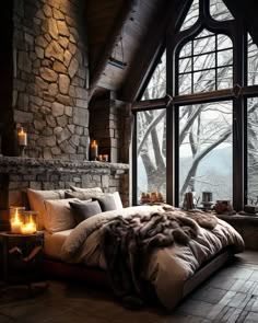 a large bedroom with stone walls and flooring is lit by candles on the bed