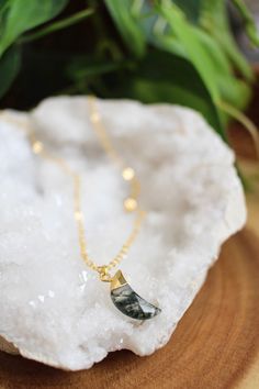 This dainty crystal moon necklace features a 21x6mm crescent moon shaped moss agate crystal, electroplated in 24K gold, and attached to a 16k gold plated chain.  The chain is available in your choice of 16, 18, or 20 inches, and is finished with a lobster clasp.  The model in the photo is wearing the 18" length for reference.  If you prefer a different length, feel free to message me. Each piece is unique, so your stone may look slightly different than the one featured in the photos. Moss agate Handmade Gold Necklace With Moss Agate, Gift Crescent Gemstone Crystal Necklaces, Dainty Gold Crystal Necklace With Moon Charm, Handmade Moss Agate Crystal Necklace For Gift, Gold Moss Agate Round Jewelry, Gold Moss Agate Pendant Jewelry, Gold Jewelry With Natural Moss Agate Stones, Mystical Moon Shaped Crystal Necklace Gift, Gold Moss Agate Spiritual Necklace