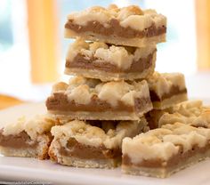 a stack of dessert bars sitting on top of a white plate