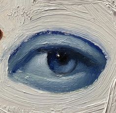 an eyeball is shown in the center of a white and blue paint covered surface