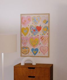 a painting on the wall next to a dresser with a lamp in front of it