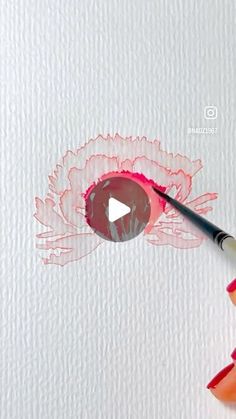 someone is painting a flower with watercolors