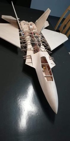 a wooden model of a fighter jet on a table