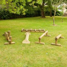 the letters are made out of logs and sticks in the grass with trees in the background