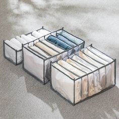 three clear storage containers filled with clothes on the ground