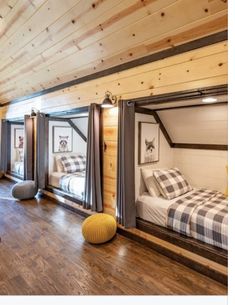 a bedroom with bunk beds and windows in the ceiling is made out of wood planks