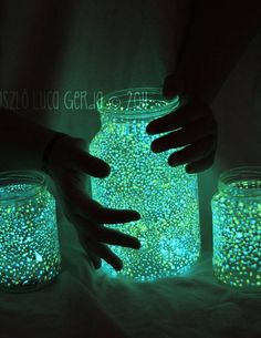 glow in the dark jars filled with small beads and hands reaching for one glowing jar