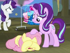 two little ponys are playing with each other in the room, and one is eating cake