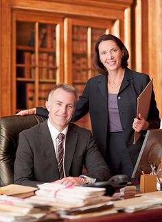 a man and woman sitting at a desk in an office