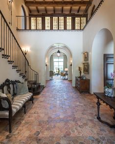 a large foyer with stone flooring and wooden staircase leading up to the second floor