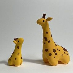 two giraffes sitting next to each other on a white surface