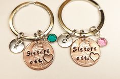 two personalized key chains with charms attached to them