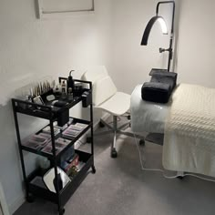 a room with a bed, desk and chair in it that has magazines on the shelf