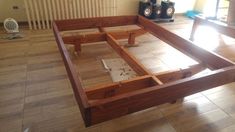 a wooden bed frame sitting on top of a hard wood floor