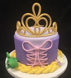 a purple and yellow cake with a tiara on top