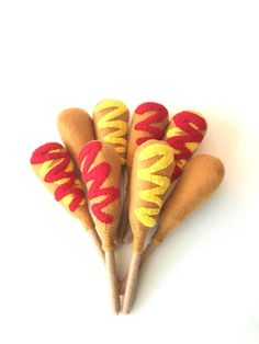 four hotdogs with yellow and red spiral designs on them are sitting in a row