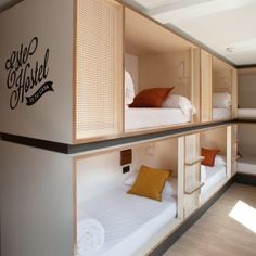 the bunk beds are built into the side of the wall and have pillows on them