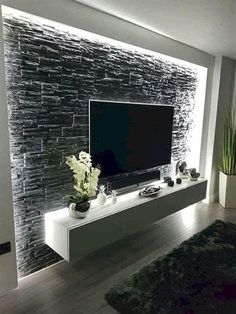 a modern living room with black and white stone wall covering the entertainment center, built into the floor