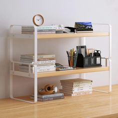 a white shelf with books and a clock on it