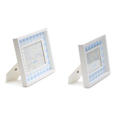 two small white frames with blue and white checkered designs on them, one is holding a camera