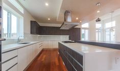 an empty kitchen with white cabinets and wood flooring