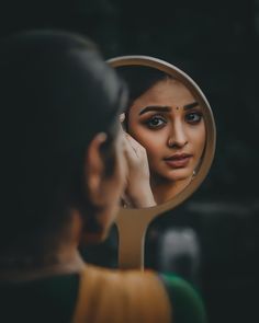 a woman is looking in the mirror with her reflection