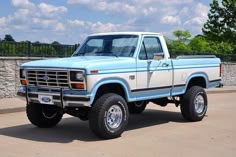 a light blue pickup truck parked in a parking lot