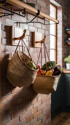 two hanging baskets filled with fruits and vegetables on a brick wall in a kitchen area