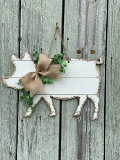 a wooden sign hanging on the side of a fence with a burlock bow