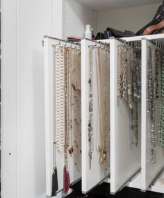 a white cabinet filled with lots of necklaces