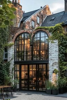 a large building with lots of windows and plants growing on it's side wall