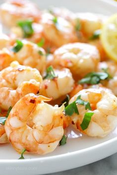 shrimp with lemon and parsley garnish on a white plate