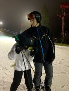 two people standing in the snow with skis on