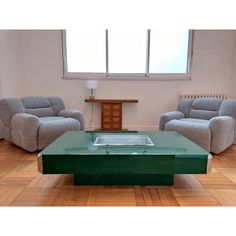 a living room with two recliners and a coffee table in front of a window