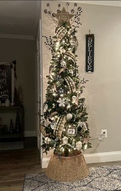 a decorated christmas tree with ornaments and lights in a living room next to a door