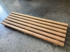 six wooden dowks are lined up on the floor in front of a bowl and plate