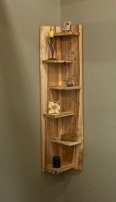 a wooden shelf mounted to the side of a wall next to a toilet in a bathroom