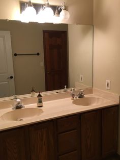 a bathroom with double sinks and mirrors in the middle of it's countertop